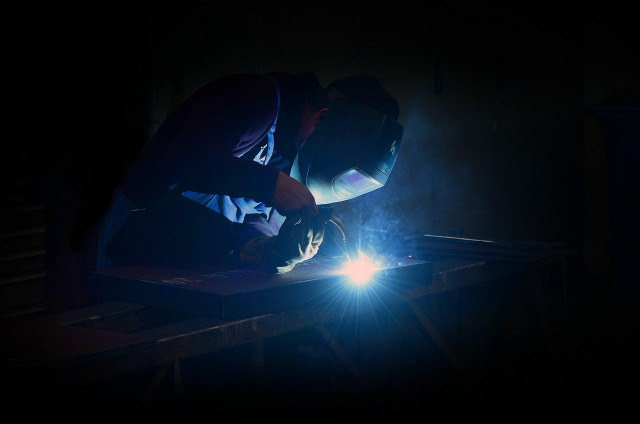Welder creating sparks in a metal workshop in Nairobi, Kenya